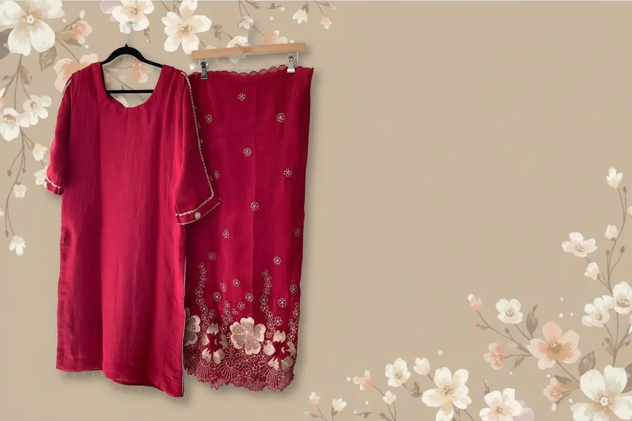 Red traditional outfit with floral embroidery on a white wall