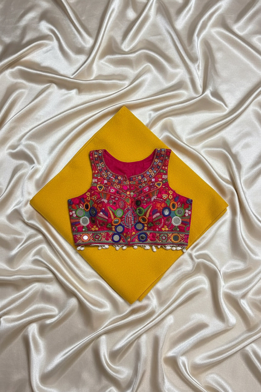 Back view of magenta Kutchi halter crop blouse showing cowrie shell fringe and mirror work detail