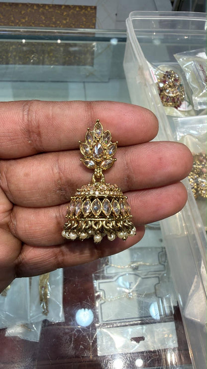 Gold jhumka earring held in hand showing lotus fan-shaped marquise CZ stud top and open cage dome body with large marquise CZ stones and faux pearl drops